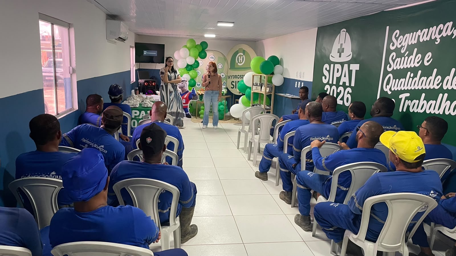 Hag Schultz e outra profissional conduzindo palestra em uma SIPAT para equipe operacional.